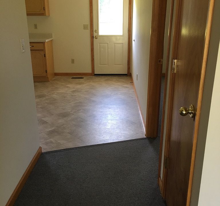 hallway into kitchen, coat closet and entrance into back bedroom