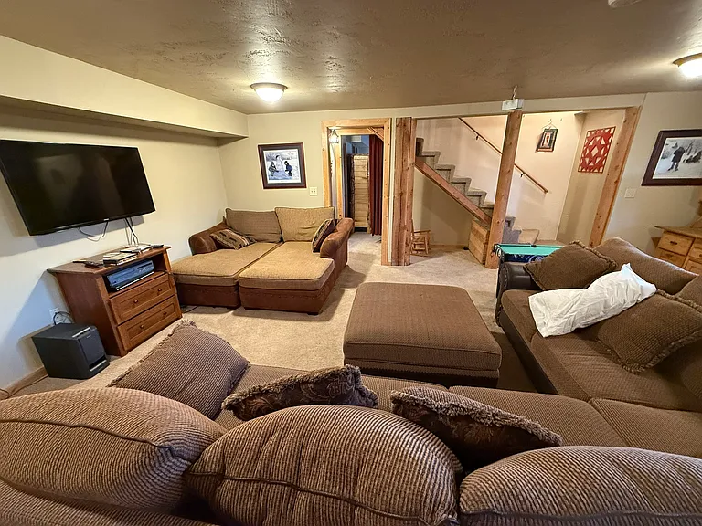 Alternate view of basement family room showing stairs and door to master bedroom