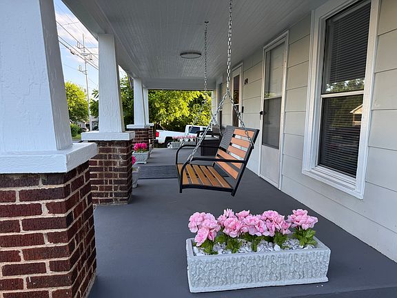 Large covered front porch with swing and bench