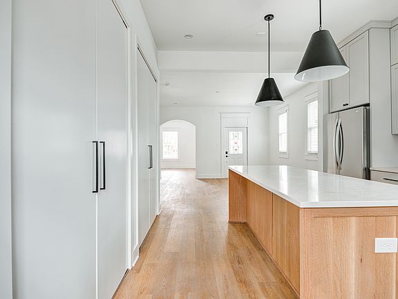 Large island with seating. Pantry and storage areas behind doors.