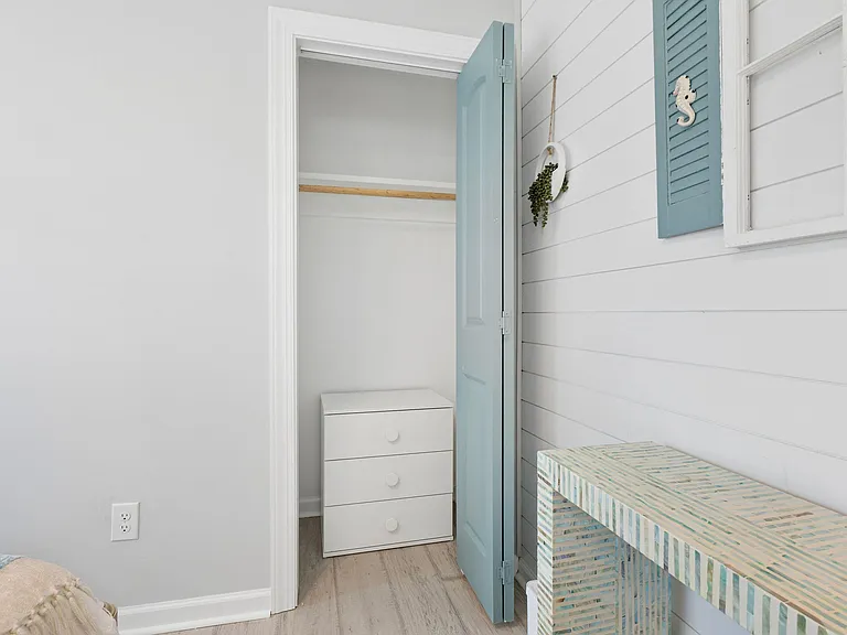 Organized closet storage area with built-in hanging rod and space for a dresser, ideal for keeping essentials within reach.