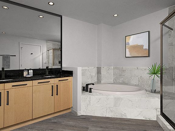 Bathroom upgrades include framed mirrors and marble-look porcelain tile surround.