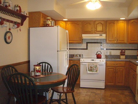 Clean Bright Kitchen Space with Sparkling Appliances, Laminate Flooring, Ceiling Fan & Tile Back Splash. 