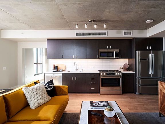 Beautiful apartment homes with espresso cabinetry, luxury stainless steel appliances, and subway tile backsplash