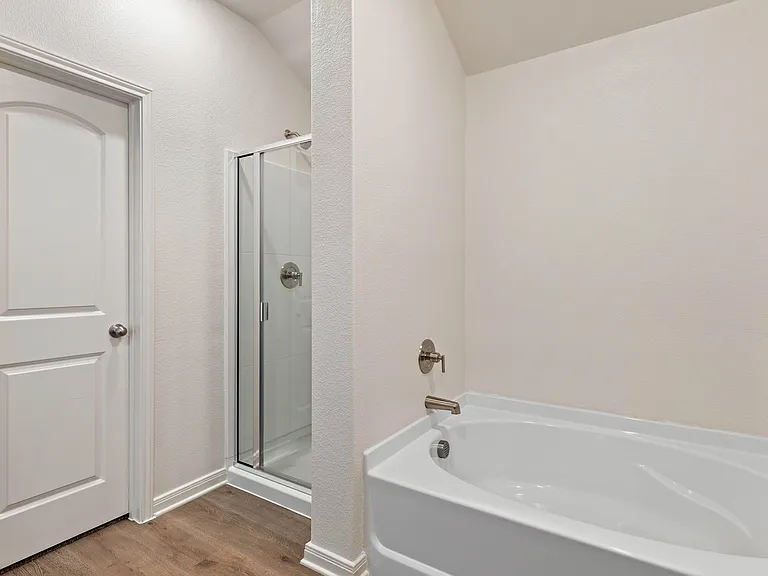 The master bathroom has a large glass, walk-in shower and garden tub.