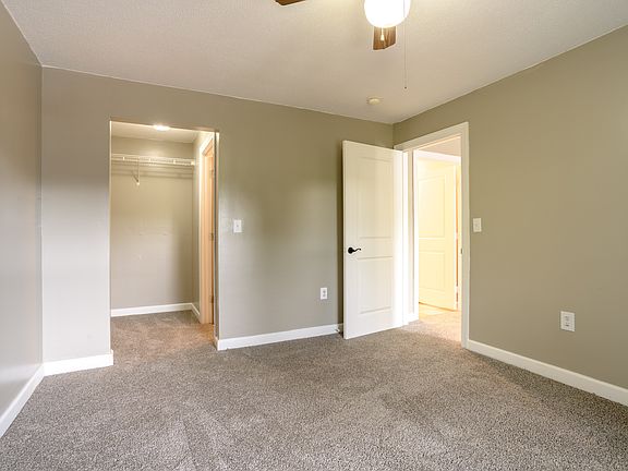 Serene bedroom with plush carpet, ceiling fan, and spacious closetdesigned for comfort and peaceful rest.