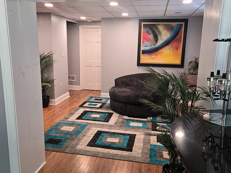 Welcoming living area with wood-look floors, recessed lighting, and comfortable seatingideal for relaxing or entertaining.