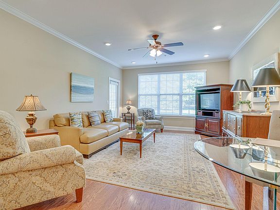 Beautiful living room with hardwood flooring with crown molding.
