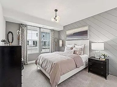 The 3rd bedroom features upgraded lighting, stylish window treatments, an elegant accent wall, and a spacious closet providing ample storage.