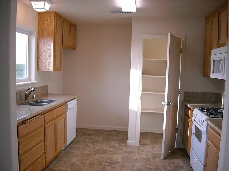 Kitchen with pantry, stove, microwave, stainless sink