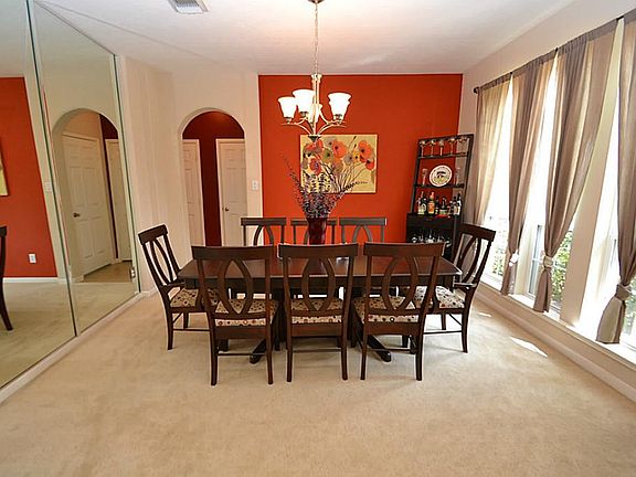 Dining room enhanced by a mirror accent wall and access to the kitchen.