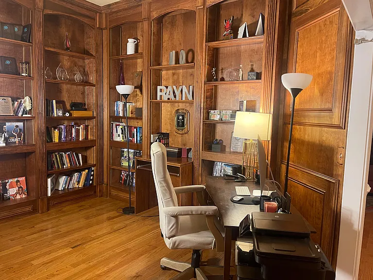 Built-in wood shelving and a dedicated desk create a functional home office or study nook with ample storage.