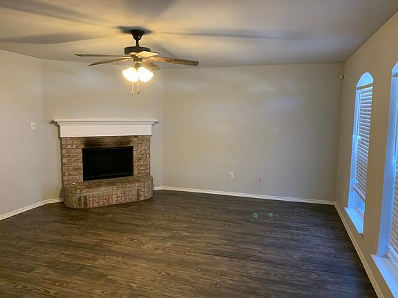 Living room with fireplace and ceiling fan.