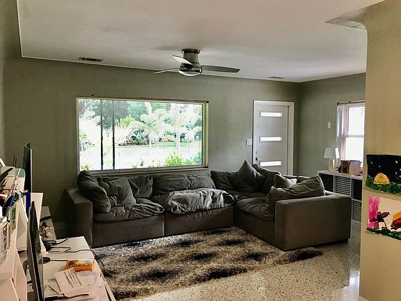 View of large and spacious living room with hurricane impact window views into the neighborhood