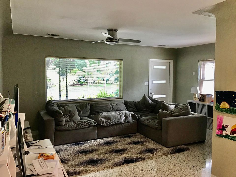 View of large and spacious living room with hurricane impact window views into the neighborhood