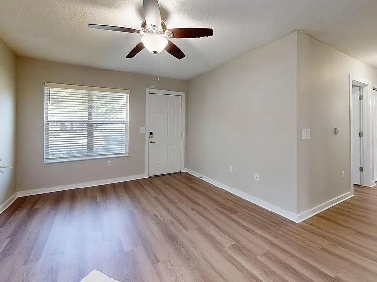 Unwind in this inviting living room space filled with natural light from a beautiful picture window, accompanied by a dedicated lighted ceiling fan for personalized comfort.
