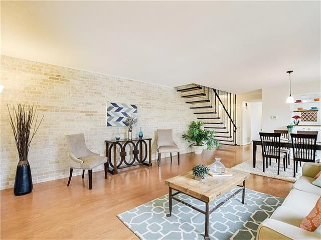 Charming and trendy - the living and dining area features a brick wall and wood floors.  Freshly painted, popcorn ceiling removed, newly installed carpet and cabinet/door hardware are also wonderful features.