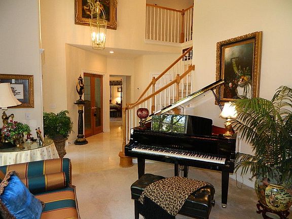 Another view of the living room as if faces the staircase and study to the left behind French doors.