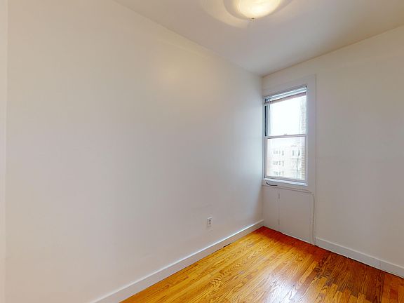 Room with wooden floor, window, and ceiling light fixture