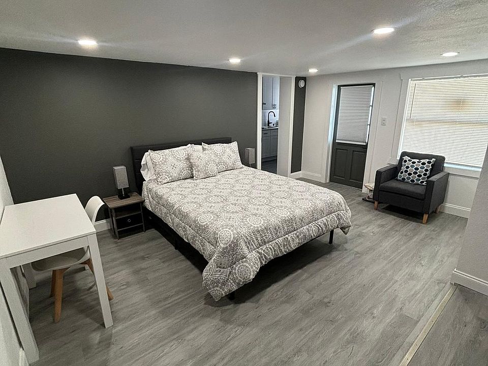 Modern room with workspace, comfy chair, and Smart TV setup.