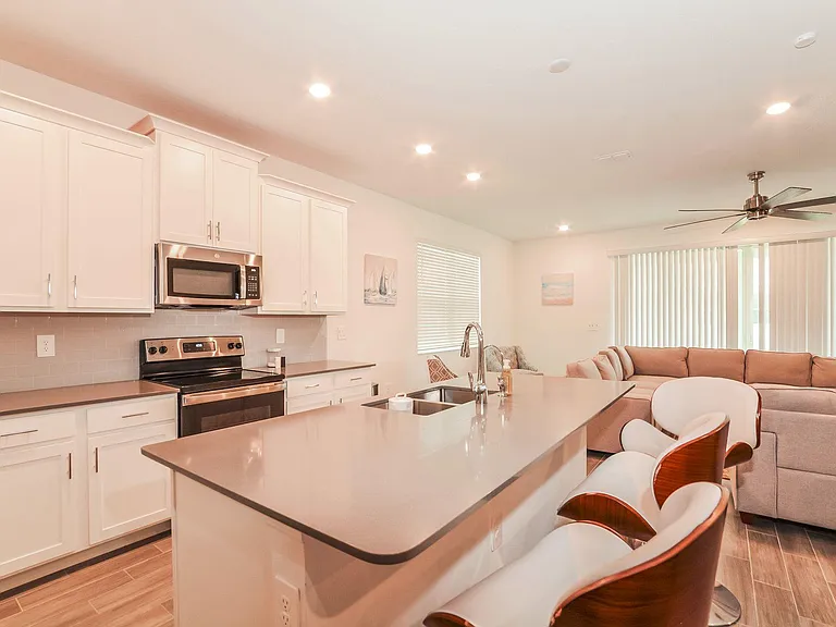 Open-concept kitchen with a large island breakfast bar, stainless appliances, and seamless flow into the living area.