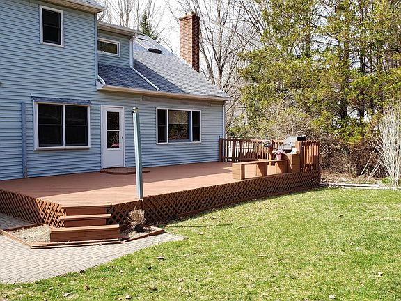 Picture showing the back deck during the late fall, which has plenty of room for patio furniture and a grill. Perfect for hosting BBQs.