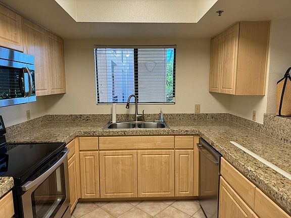 The kitchen has ample storage, a great recessed light fixture, a microwave, a dishwasher, and a window over the kitchen sink. Plus, a bar area to catch a bite to eat, drop your keys as you walk in the door, or serve drinks and food to friends.