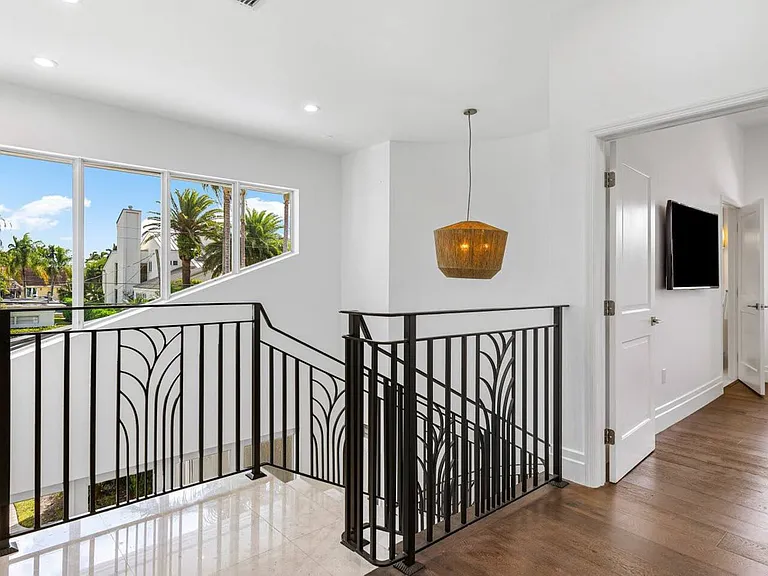 Ascend to the upper level and enjoy bright, open views framed by elegant wrought-iron railings.