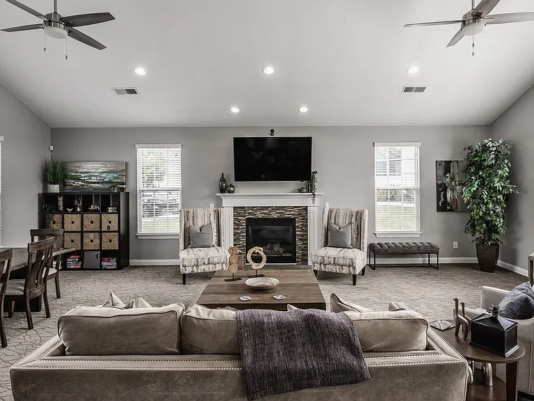Enjoy a spacious living area designed for relaxation and gatherings, featuring natural light, a cozy fireplace, and a welcoming layout.