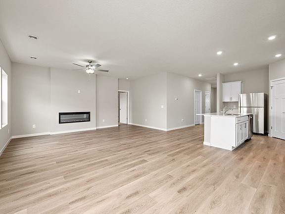 The family room is spacious with a ceiling fan and fireplace.
