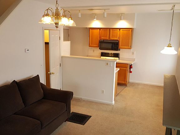 Living room first floor with view of kitchen and stairway.