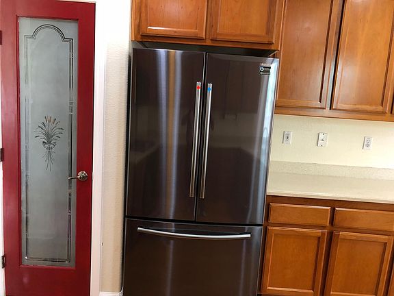 BLACK STAINLESS STEEL FRNCH DOOR 
REFRIGERATOR SAMSUNG WITH ADJACENT PANTRY