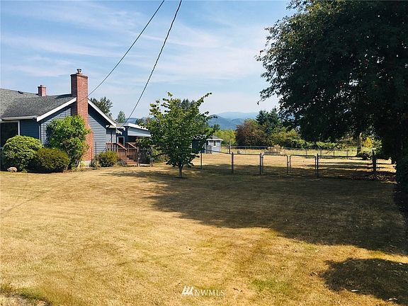 Looking east down the southern border of the property. Large fenced side yard leads to the pasture in back.