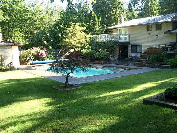 Pool house on left...standing next to steel fire pit area.