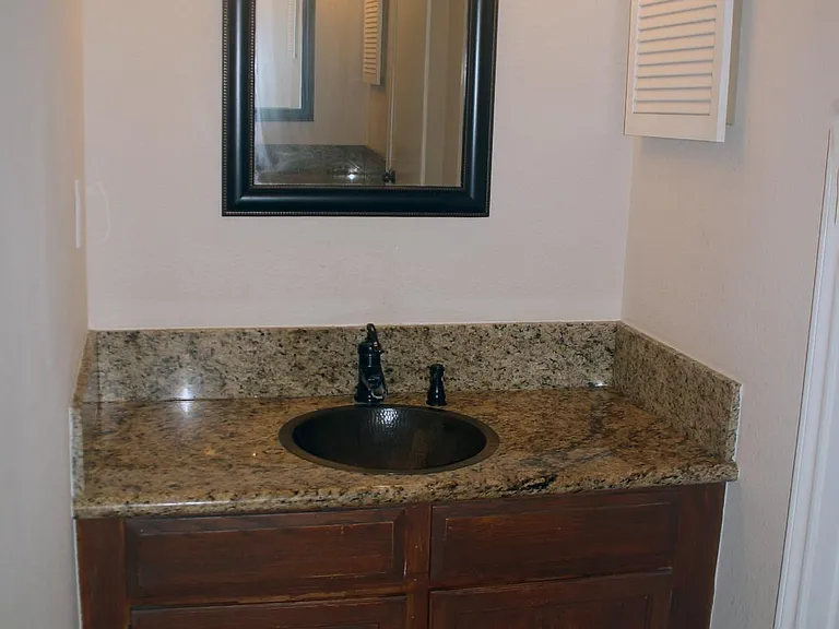 Master bedroom sink, granite counter top, copper sink, and bronze fixture