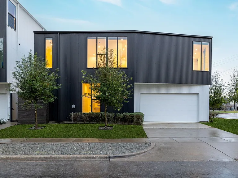 Contemporary architectural design featuring a dark siding facade and white accents