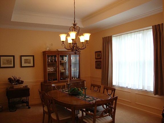 Dining room has tray ceiling and wainscoting.