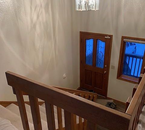 Entryway with long stairs to upstairs. This unit also has a large window above the door.