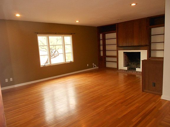 Living Room with real wood floors, fireplace and ample book 