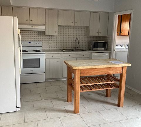 Large oversized kitchen with space for dining table, and a separate laundry room and pantry