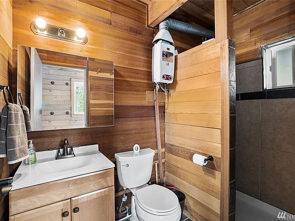 Main floor 3/4 bath with slate floors, tiled shower, & cedar wall. Tankless on-demand hot water.