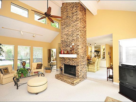 Windows are everywhere! Notice the windows that are higher, allowing more light, and the ability to see the beautiful blue sky!  The stone fireplace is such a striking feature to this room.