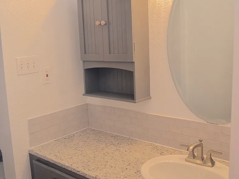 Guest house bathroom sink with granite countertops.