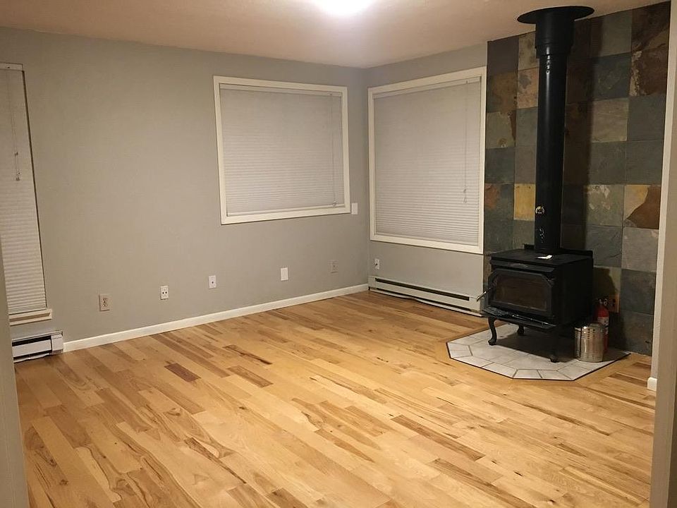 Living room, unfurnished with wood stove.