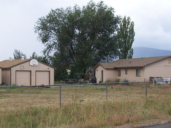 Side view showing fenced acre + lot with detached 2 car garage & add'l storage