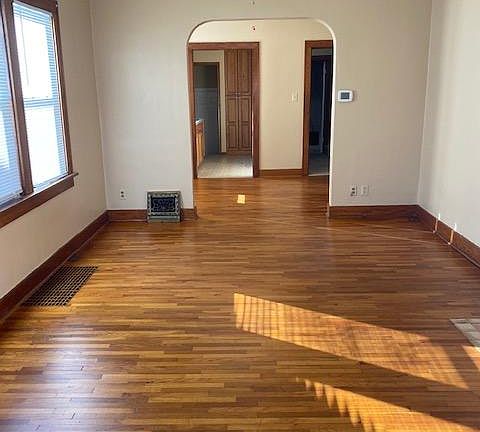 Living room looking towards dining room Original hardwood floors South windows