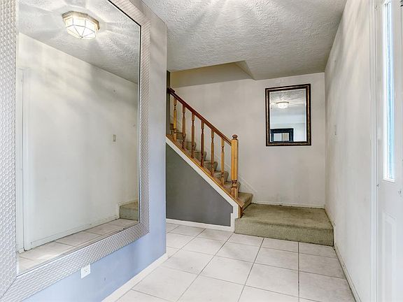 Tile Foyer opens to living room and stairs to bedrooms.