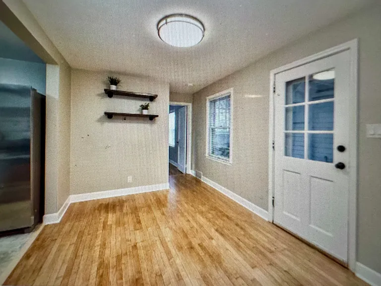 Back door, dining space with beautiful maple flooring.