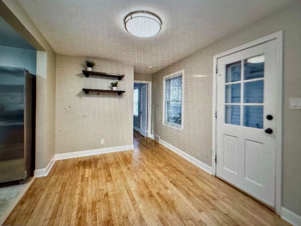 Back door, dining space with beautiful maple flooring.