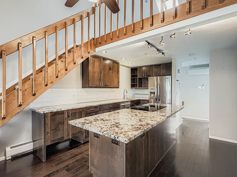Granite counters, stainless appliances, alder cabinets, and wood laminate floors.